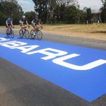 Autocollant extérieur sur mesure rectangulaire géant apposé sur l'asphalte où roulent des cyclistes de compétition